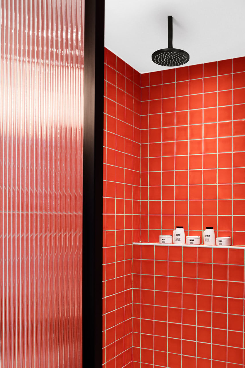 Seaview Room - Rainfall shower with vibrant terracotta tiles and refillable bathroom amenities.