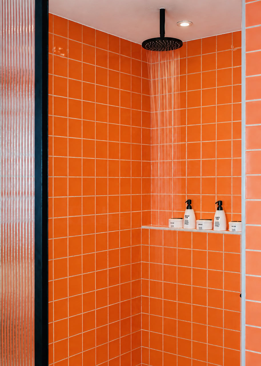 Bang on Beach - Rainfall shower with vibrant terracotta tiles and refillable bathroom amenities.