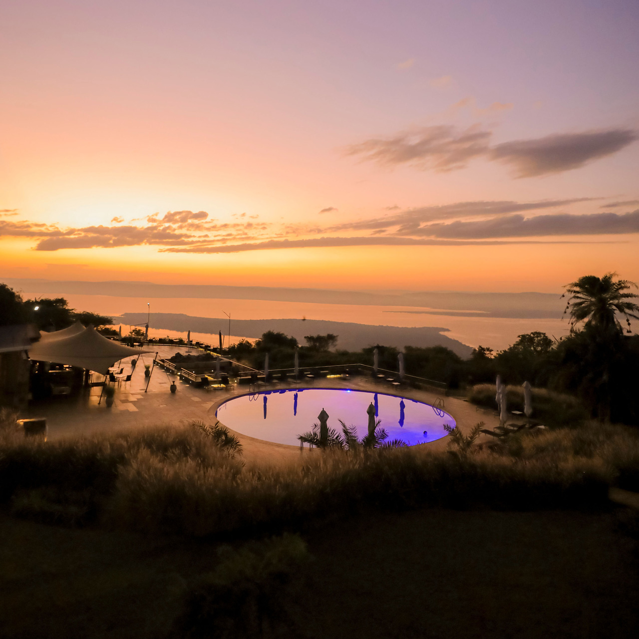 Sunset over Lake Ihema and the pool at SALT of Akagera.