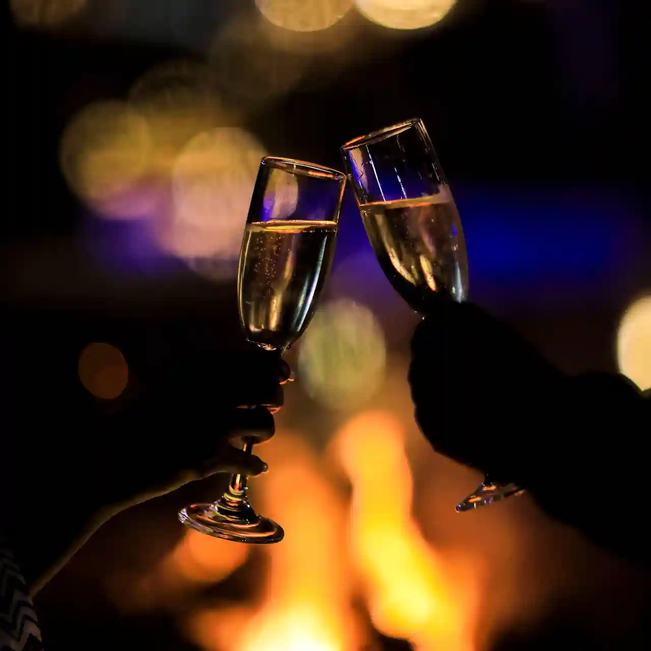 Guests raising glasses by the fire at SALT of Akagera.